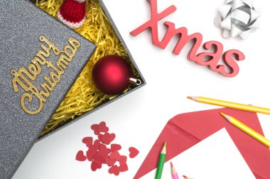 Merry christmas ve X-mas metin, kalp siyah hediye kutusunda sarı ambalaj malzemesi ile kürk şapka, top, şerit, yılbaşı kartı, renkli kalemler,