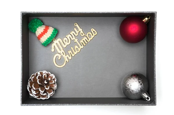 Merry christmas tekst en bont hoed, bal, dennenappel in zwarte geschenkdoos — Stockfoto