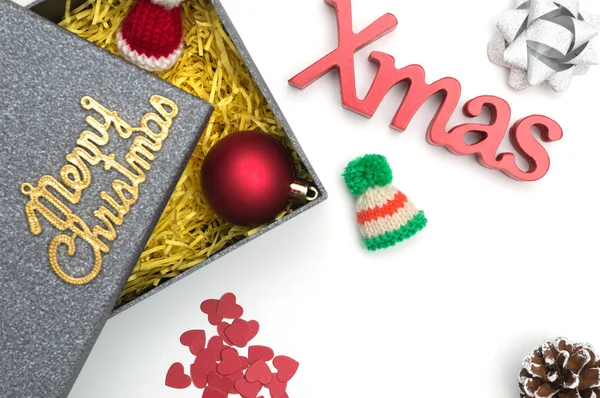 Merry christmas ve X-mas metin, kürk şapka, top, şerit, çam kozalağı, siyah hediye kutusunda sarı ambalaj malzemesi ile kalp