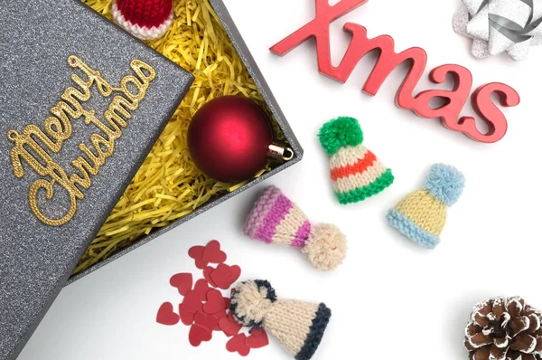 Merry christmas ve X-mas metin, kürk şapka, top, şerit, çam kozalağı, siyah hediye kutusunda sarı ambalaj malzemesi ile kalp