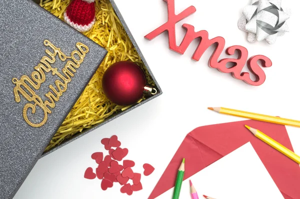 Merry christmas ve X-mas metin, kalp siyah hediye kutusunda sarı ambalaj malzemesi ile kürk şapka, top, şerit, yılbaşı kartı, renkli kalemler,