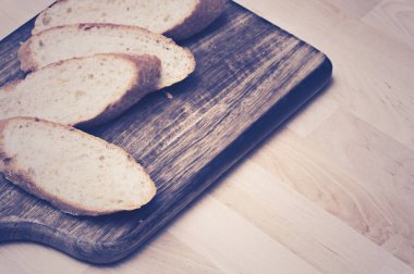 Ahşap plaka üzerinde baget ekmek dilimlenmiş