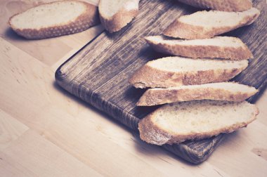 Ahşap plaka üzerinde baget ekmek dilimlenmiş
