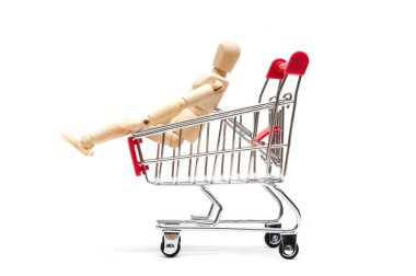 Ahşap bebek ve beyaz arka plan üzerinde alışveriş sepeti: Ekonomi konsantrasyon