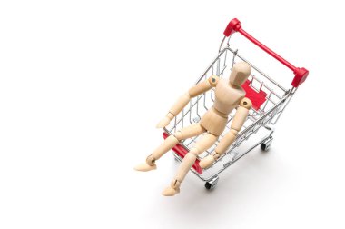 Ahşap bebek ve beyaz arka plan üzerinde alışveriş sepeti: Ekonomi konsantrasyon