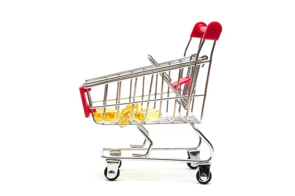 Pills and shopping cart on white background : economy concept — Stock Photo, Image