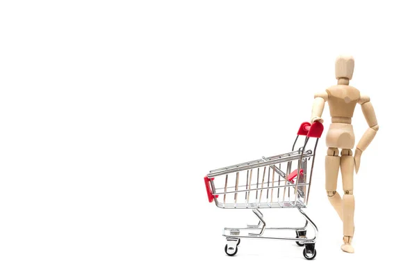Wooden doll and shopping cart on white background : economy conc — Stock Photo, Image
