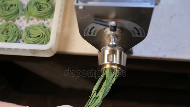 Processed green spaghetti pasta on machine tray at kitchen — Stock Video