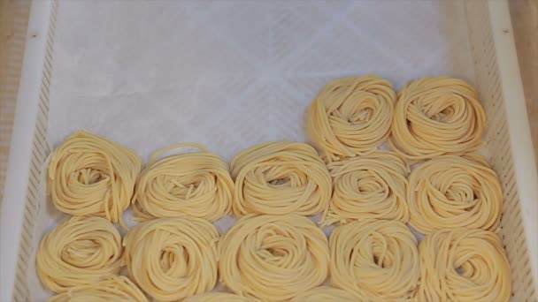 Tagliatelle de pasta fresca de una máquina de pasta tradicional. De cerca. — Vídeos de Stock