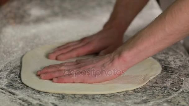 Мужские руки месят тесто в муке на столе — стоковое видео