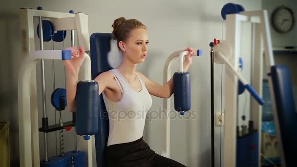 Αθλητική νεαρή γυναίκα κάνει άσκηση με προσομοιωτή στο γυμναστήριο στο σπίτι — Αρχείο Βίντεο