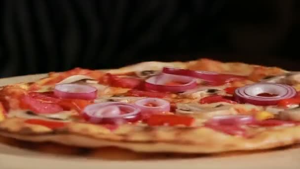 Pizza recém-assada com pepperoni, cogumelos, cebola e pimenta dá a volta. Vista frontal — Vídeo de Stock