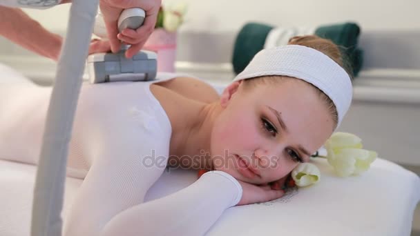 La donna sta lavorando al lipomassaggio della clinica. Massaggio al GPL nel centro estetico. Donna sdraiata sul letto in un salone termale godendo e ricevendo lipo procedura di massaggio. Trattamenti Spa, centro estetico — Video Stock