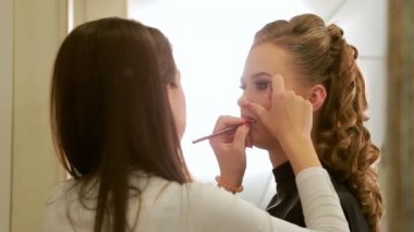 Ruj kozmetik fırça ile uygulama modelinin dudaklar, yakın çekim, model makyaj sanatçısı