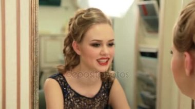 Partiden önce kendi kendine gülümser ve ayna şaşırtıcı makyaj ve saç akşam elbiseli güzel kızla arar