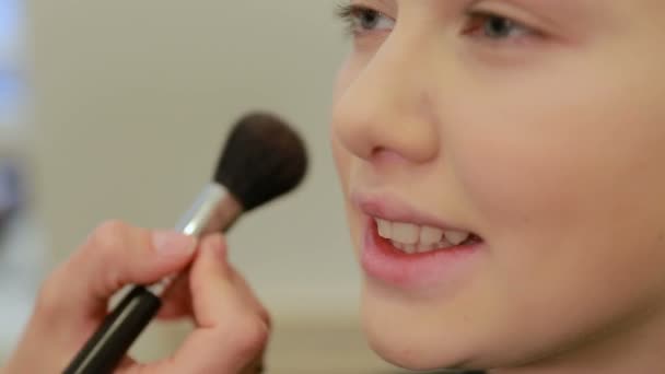 Maquillaje artista mano aplicando cosmética con un gran cepillo de maquillaje. Maquillaje de una modelo femenina sonriente — Vídeos de Stock