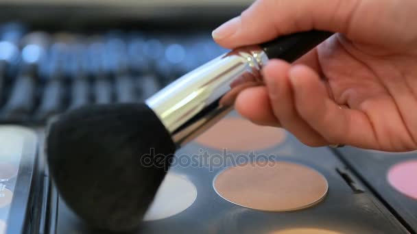 Imágenes de cerca de una paleta de maquillaje y un maquillador usando pincel de polvo para tomar un color de la paleta ... — Vídeos de Stock