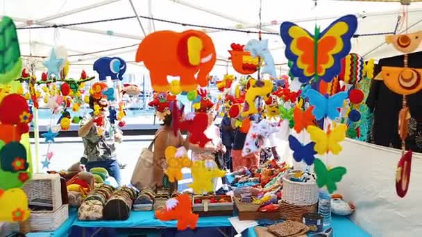 Mångfärgade handgjorda souvenirer och leksaker säljs på gatan marknaden i Barcelona den 23 augusti 2015 — Stockvideo