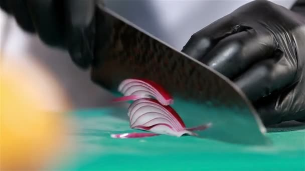 Chef cuts up purple onion using knife to slice. Close up — Stock Video