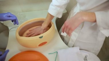Parafin terapi için kozmetik kliniğinde eller