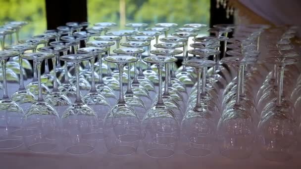 Vasos vacíos para vino y agua colocados en una mesa festiva en un restaurante enfocan el turno de cristalería. Decoración de mesa — Vídeo de stock