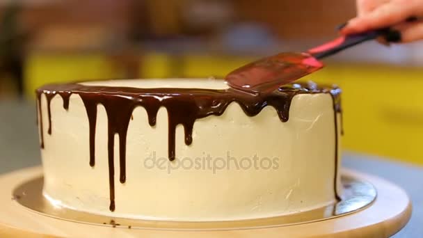 Pasticciere che fa la torta al cioccolato. Il processo di fare una torta. Pasticceria coperta torta al cioccolato da crema. Dolcificante identifica crema biscotto con spatola pasticcera. Torta rotonda al cioccolato — Video Stock