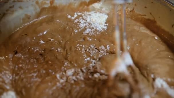 Using an electric mixer to beat chocolate or cocoa powder, baking powder and flour. Close up view — Stock Video