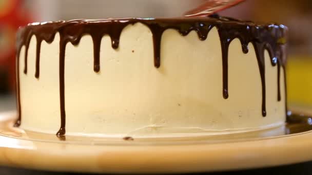 Lo chef stringe la crema. Ciliegina di cioccolato sulla torta. Torta bianca ricoperta di cioccolato e panna. Decorazione torta al cioccolato. Torta rustica. Pasticceria. Pasticciere. Torta moderna . — Video Stock