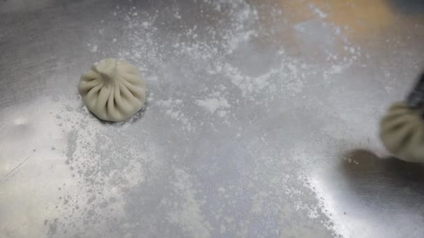 Cuisine nationale géorgienne Khinkali. Gros plan de mains de chef mettant Dumplings sur plateau. Lignes aliments crus prêts à cuire — Video