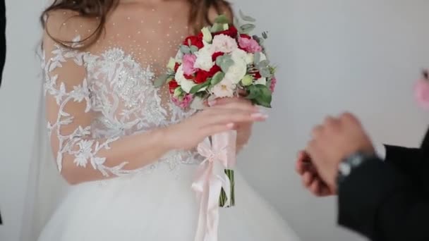 O noivo coloca um anel de casamento dourado no dedo das noivas. A noiva eo noivo estão envolvidos. — Vídeo de Stock