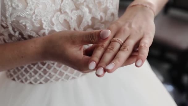 La sposa porta la fede al dito prima del matrimonio. Sposa in abito da sposa toccare la sua fede nuziale d'oro — Video Stock