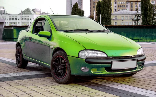 Pequeno sportcar velho verde contra a paisagem da cidade — Fotografia de Stock