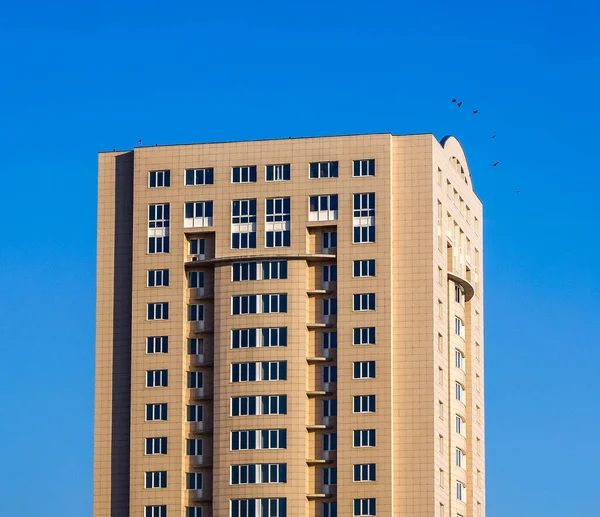 High multi storey building against blue sky in sunny day — Stock Photo, Image