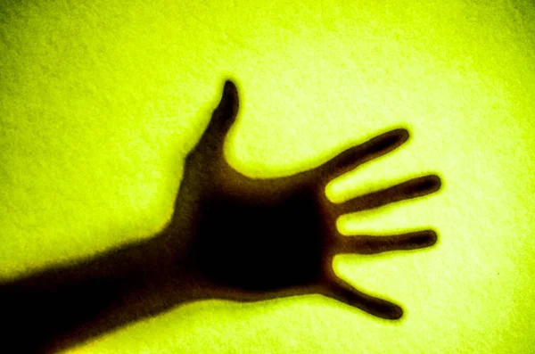 Buzlu camın arkasındaki adamın gölgeli elleri.