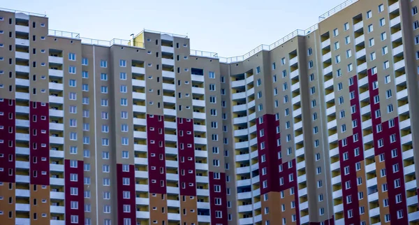 Kırmızı ve fildişi tuğlalarla yapılmış birçok aile için çok katlı büyük bir ev.