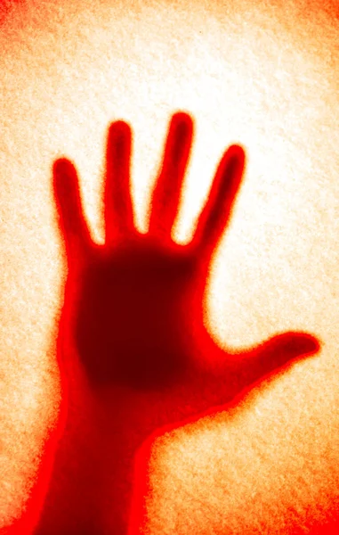 Kırmızı kanlı el gölgesi turuncu arka planda. Garip kanlı el.