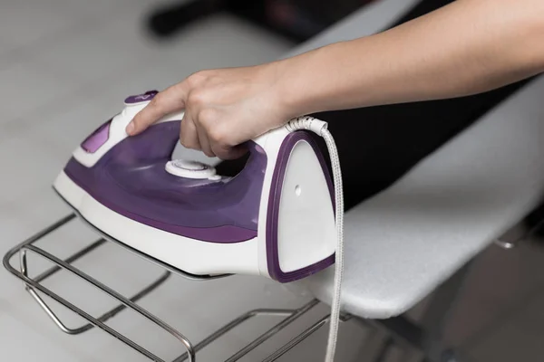 stock image Young woman is using steam iron on her cloths