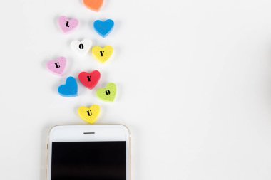 Renkli kalpler ile smartphone beyaz arka planda, aşk kavramı üzerinden göndererek mesaj seviyorum