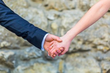 Gelin ve damat el ele tutuşuyorlar.