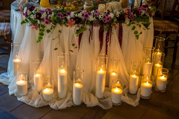 Molte candele in vasi intorno al tavolo del banchetto — Foto Stock