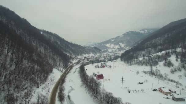 Volo sulla strada di montagna e sul fiume in inverno — Video Stock