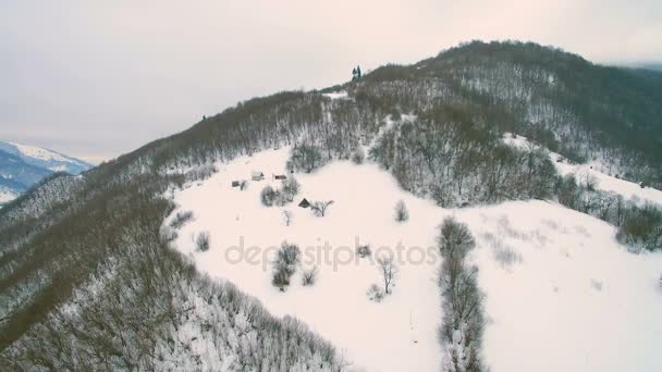 4K Pueblo de montaña con casa residencial cubierta por fuertes tormentas de nieve caen en invierno durante el día — Vídeos de Stock