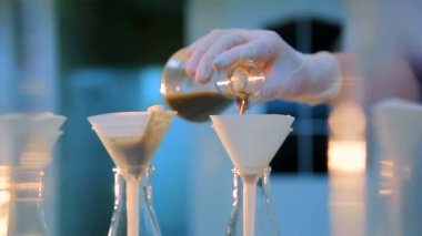 Test, laboratuvar kimyager onay temiz suda düz dipli şişeye su ve sonuçları yazmak