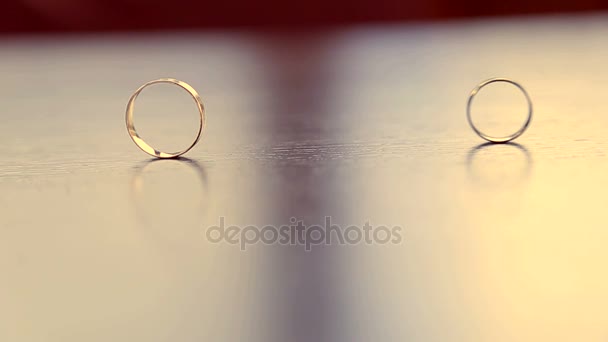 Свадебные кольца на столе — стоковое видео