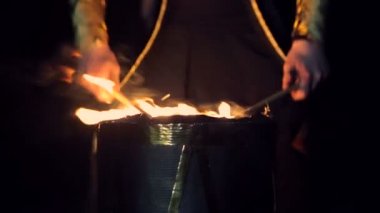 Yakın çekim. Adam yakma davul çalıyor. Yanıp sönen ışıklar zemine karşı