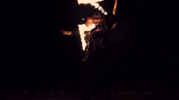 Две девушки танцуют с огнем. Огненное шоу потрясающее ночью. Танцы с огнем ночью . — стоковое видео
