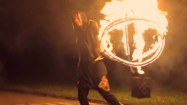 Mannen vänder i sina händer en boll av eld. Stor eldshow. Slow motion. — Stockvideo