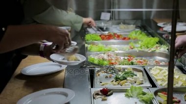 İnsanlar yemek empoze. Yemek Servisi. Salata empoze. Gıda dağıtım tablosu.