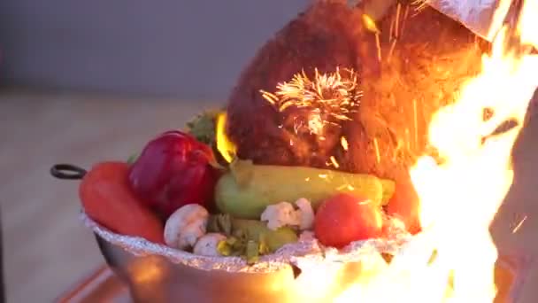 Pierna de cerdo grande pechenitsa en el fuego con verduras — Vídeo de stock