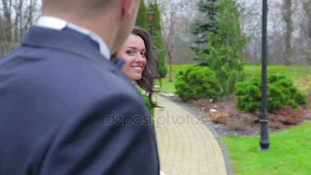 Braut und Bräutigam spazieren im Park — Stockvideo